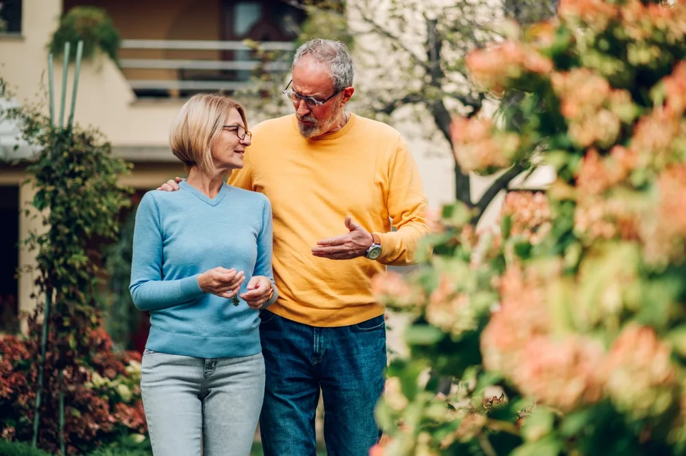 Mature couple walking outside a house