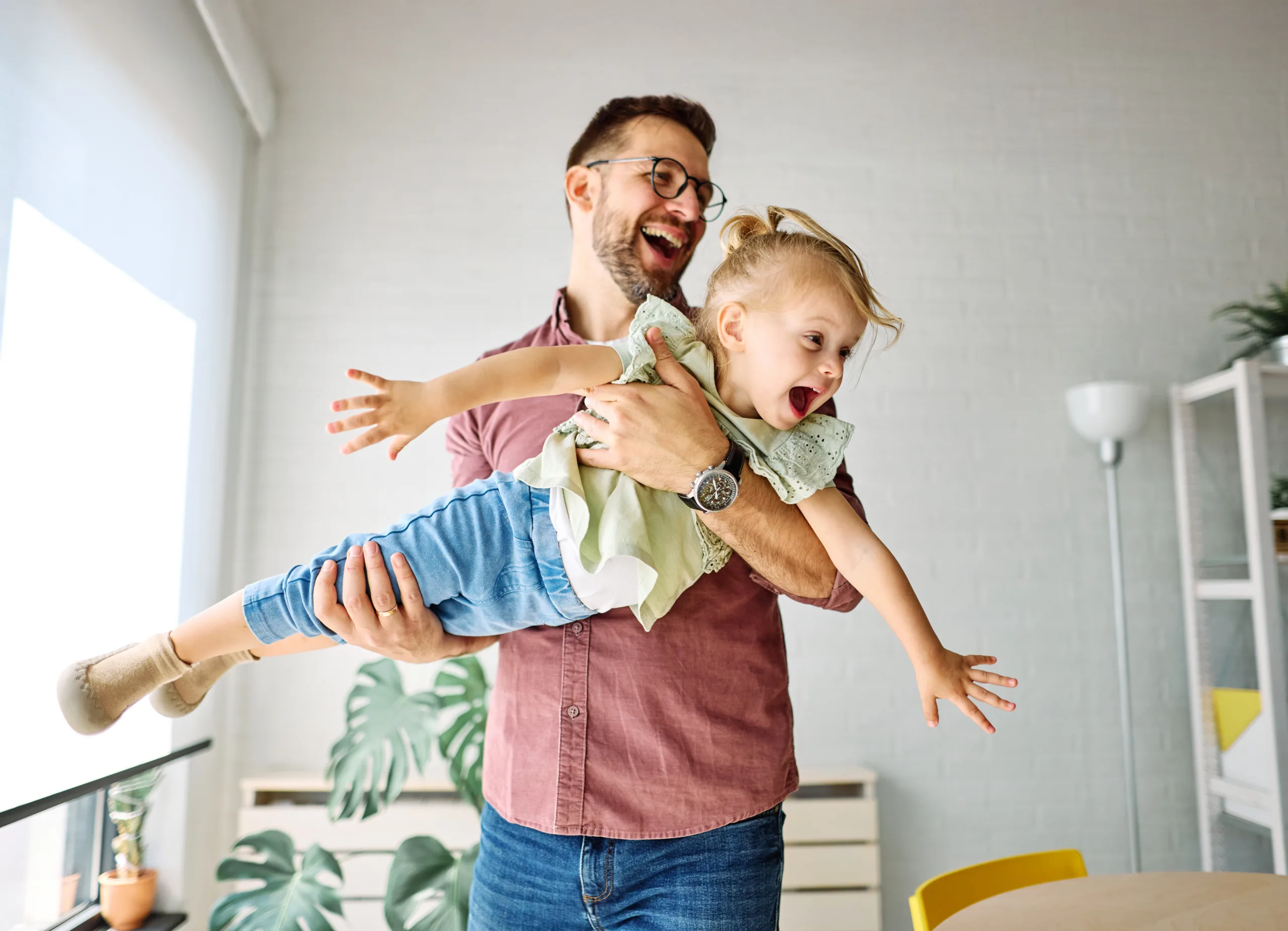 A father playing with his young daughter.
